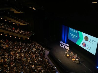 A panel discussion on stage in front of a seated audience