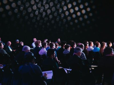 Delegates seated in a large conference hall facing the stage