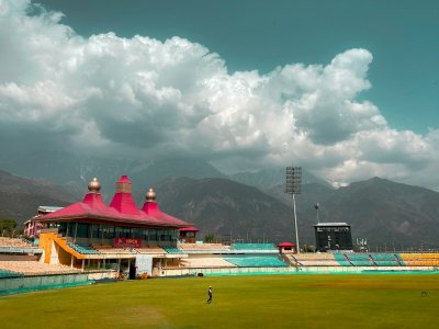 Cricketers on a green outfield under a bright blue sky