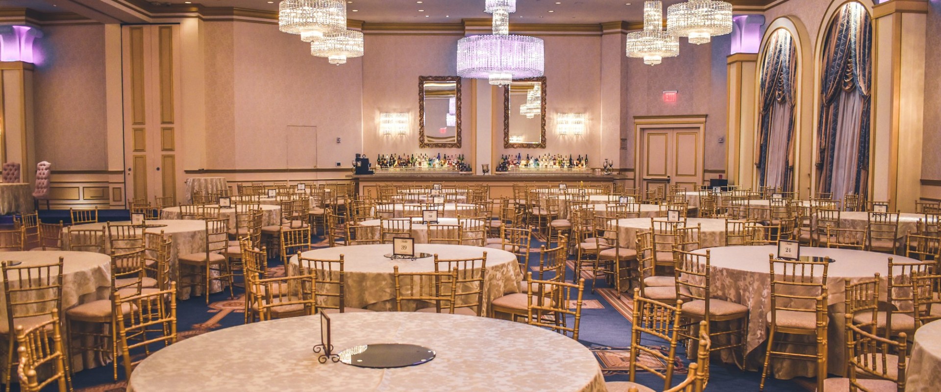 Round tables dressed for a formal gala dinner in a banquet hall