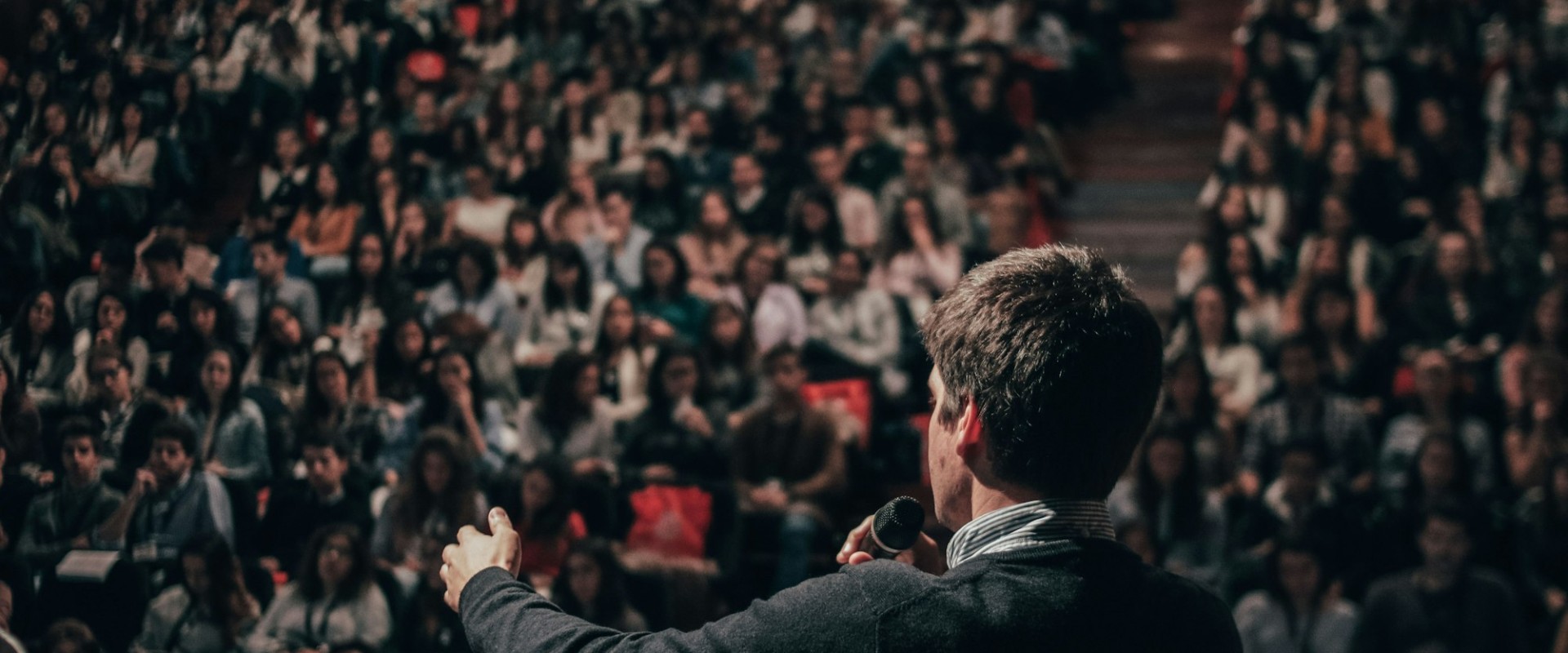 A speaker on stage addressing a conference audience