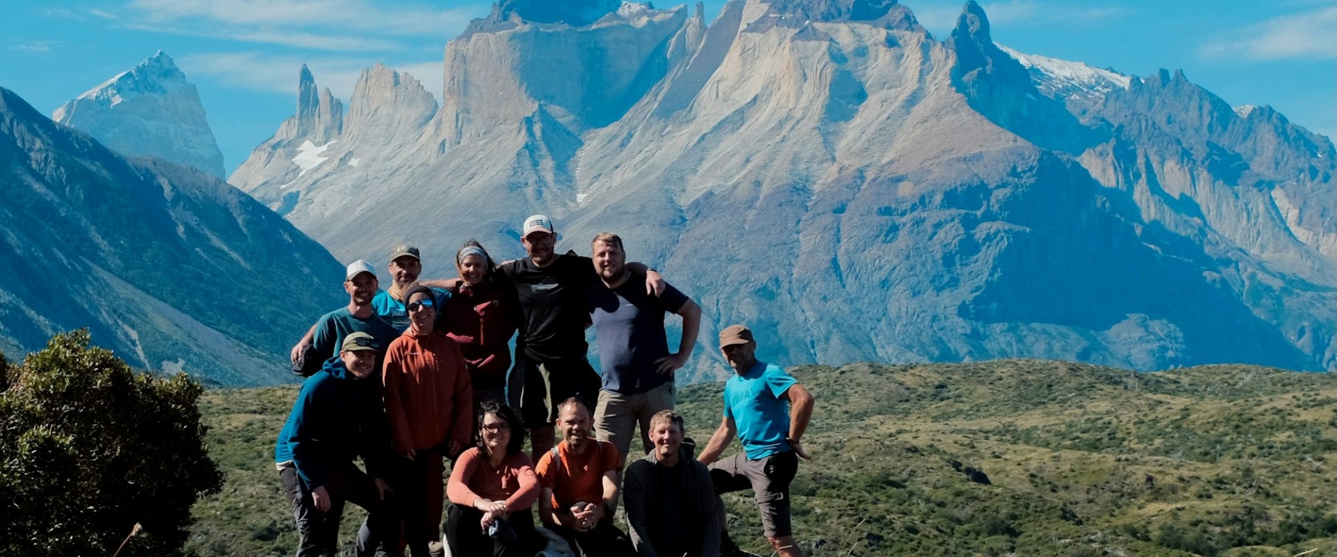 A group of hikers posing before a mountain backdrop