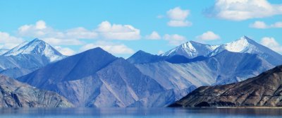 A high-altitude lake ringed by barren mountains in Ladakh under a blue sky