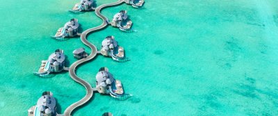 Aerial view of overwater villas over a turquoise lagoon in the Maldives