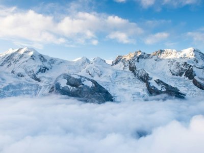 Snow-capped Alpine peak rising above a sea of clouds