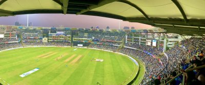 Spectators in the stands watching a match on a sunny day